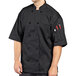 A man wearing an Uncommon Chef black short sleeve chef coat with mesh back.