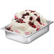 A bowl of white ice cream with red cherry variegate on top.