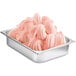 A metal container filled with pink frozen dessert mix.