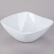 A white square bowl with a flared rim on a gray surface.