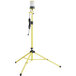 A yellow tripod stand with a black Lind Equipment Beacon360 LED area light on it.
