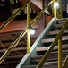 Lind Equipment 50' string lights with yellow metal guards on a yellow railing.