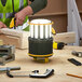 A man using a Lind Equipment Beacon360 GO Portable Area Light on a woodworking project.