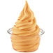 A clear cup of orange soft serve with swirled ice cream.