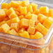 A plastic container of yellow cubes of Pitaya Foods Passion Fruit.