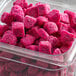 A plastic container of pink food with Pitaya Foods diced dragon fruit cubes inside.