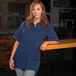 A woman wearing a navy blue Mercer Culinary cook shirt.