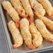 A white tray of close up of Handy Coconut Breaded Shrimp.