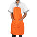 An orange Uncommon Chef apron with 3 pockets.