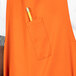 An orange Uncommon Chef apron with a pencil in the pocket.
