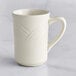 An Acopa ivory stoneware mug with an embossed wavy design on the surface and handle.