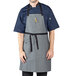A man wearing a grey Uncommon Chef bib apron with black webbing.
