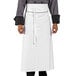 A person wearing a white Uncommon Chef executive apron with black piping.