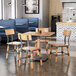 A Lancaster Table & Seating natural wood live edge table and chairs in a restaurant