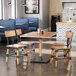 A Lancaster Table & Seating live edge wooden dining table with chairs in a restaurant.