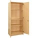 A Tot Mate maple wooden double-door tall cabinet with shelves.