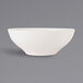 A white Tuxton China bowl with a small rim on a gray background.