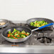 Two Vollrath aluminum non-stick fry pans with blue Cool handles, one filled with vegetables.