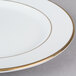 A CAC bright white porcelain plate with a gold rim.