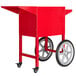A red Carnival King popcorn cart with wheels.