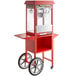 A red Carnival King popcorn cart with a popcorn popper on it.