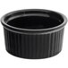 An Acopa black fluted stoneware ramekin with a white background.