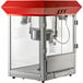 A red and silver Carnival King popcorn machine with a glass top.