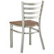 A Lancaster Table & Seating metal ladder back chair with a wood seat.