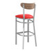 A Lancaster Table & Seating Boomerang bar stool with a red vinyl seat and vintage wood back.