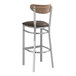 A Lancaster Table & Seating bar stool with a dark brown vinyl cushion and wood back.