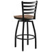 A Lancaster Table & Seating black swivel bar stool with a vintage wood seat.