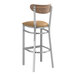 A Lancaster Table & Seating bar stool with a light brown vinyl seat and vintage wood back.