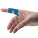A finger with a Blue Woven Adhesive knuckle bandage on it.