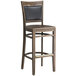 A Lancaster Table & Seating Sofia vintage wood bar stool with a wood seat.