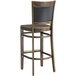 A Lancaster Table & Seating Sofia wood bar stool with a vintage wood seat.