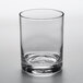 An Arcoroc customizable rocks glass filled with a small amount of liquid on a white background.