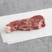 A piece of Kinikin Processing Rocky Mountain New York strip steak on white paper.