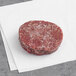 A raw Kinikin Processing Rocky Mountain Elk Burger on a white napkin.