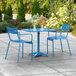 A blue table and two chairs on a patio.