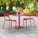 A red table and chairs on a patio.