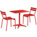 A red Lancaster Table & Seating dining height outdoor table with two chairs.