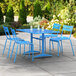 A blue Lancaster Table & Seating outdoor dining set on a patio with drinks on the table.
