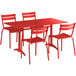 A red Lancaster Table & Seating outdoor dining table with four chairs set up on a patio.
