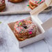 A box of Rich's jumbo plain cake donuts with a donut with sprinkles on top.