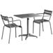 A Lancaster Table & Seating matte gray aluminum table with two arm chairs on an outdoor patio.