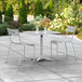 A white table and chairs on a stone patio.