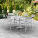 A Lancaster Table & Seating silver aluminum outdoor dining set on a concrete patio.