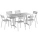 A Lancaster Table & Seating outdoor dining set with a white table and six white chairs.