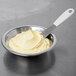 A metal bowl of Rich's Bettercreme Lemon Whipped Icing with a spatula.