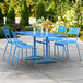 A blue Lancaster Table & Seating outdoor dining set with table and four chairs.